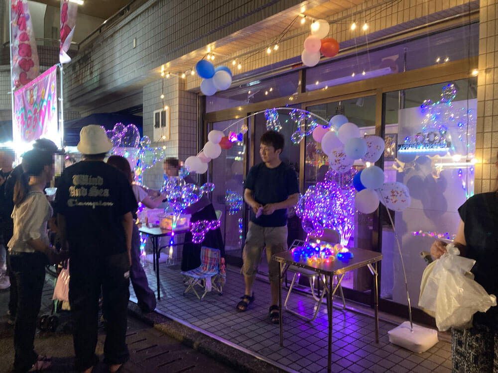 飾りつけあっれた会社の玄関で光るLED風船を販売するクオックス代表